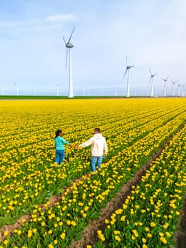 Men and women in flower fields seen from above with a drone in the Netherlands, Tulip fields in the Netherlands during Spring, diverse couple in a spring flower field