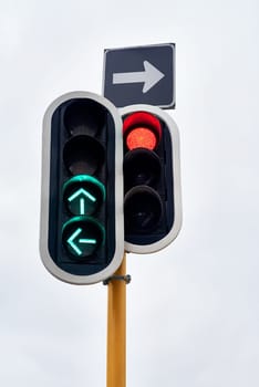 Traffic light, green and arrow with stop at street intersection for transportation directions, driving or downtown. Road safety, urban and commute with outdoor caution or go signal, rules or city.