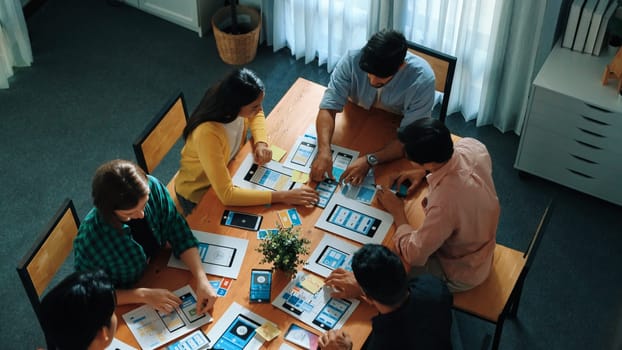 Top view of developer team designing Ux Ui design for phone interface or planning for making digital development. Startup project send develop plan to manager while sitting at boardroom. Convocation.