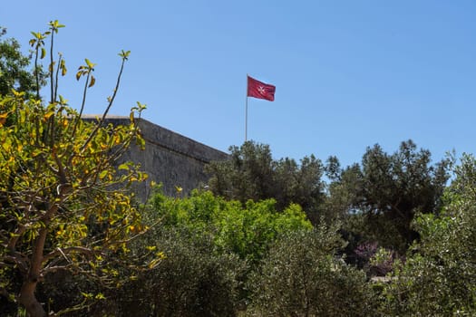 Valletta, Malta, April 03, 2024.  the flag with the Maltese cross flying on the ramparts in the city center