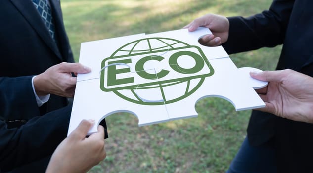 Business people or corporate partnership joining ECO friendly idea puzzle of jigsaw together as group of eco professional teamwork concept to promote social awareness on environmental protection. Gyre