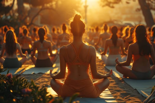 A group of young girls practicing yoga in the sunlight perform Padmasana exercises, lotus position.