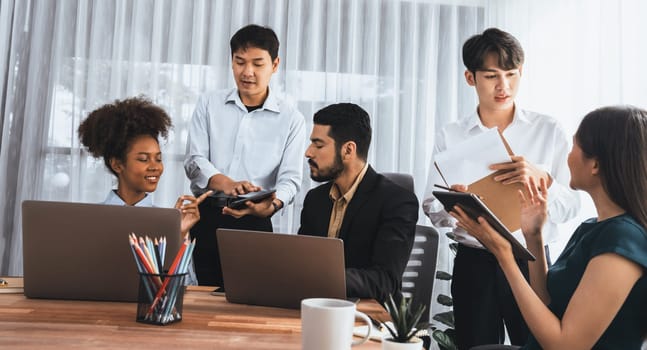 Happy diverse business people work together, discussing in corporate office. Professional and diversity teamwork discuss business plan on desk with laptop. Modern multicultural office worker. Concord