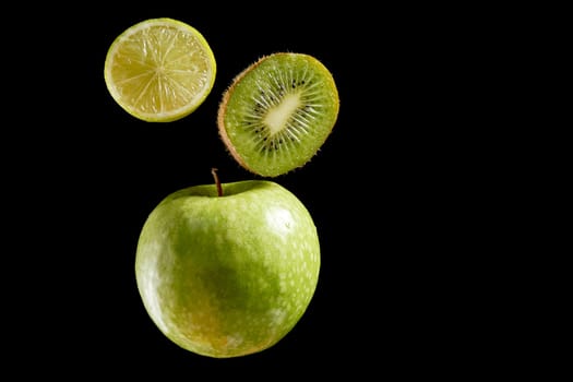 Green fresh organic fruits halves on black background