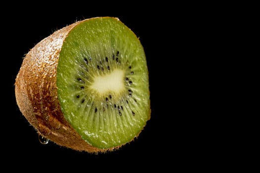 Green fresh organic half kiwi on black background