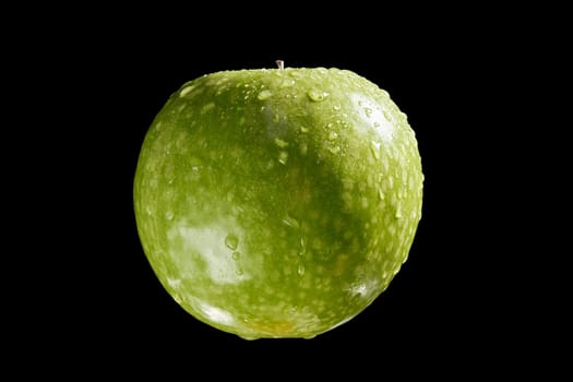 Close up of green organic fresh apple with water drops on black background