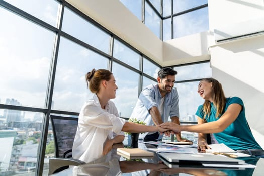 Group of skilled businesspeople putting hands together at modern office.Happy smart business team working together. Represented unity, love, team, working together, partnership, work place. Tracery.