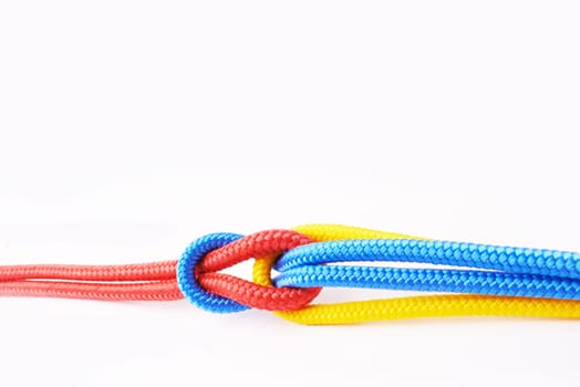 Colourful, ropes and tied for together in studio to represent unity, connect and trust. Secure, string and reef knotted for security to stop movement of objects safety on isolated white background.