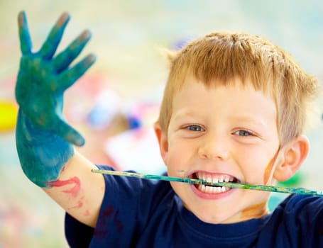 Boy, paint and mess or playing portrait, happy child in preschool or childhood fun. Educational development, smile and finger or face painting for art, recreation activity for growth together.