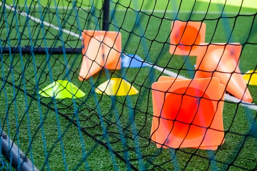 Soccer goal and cones on green artificial turf, sport background.