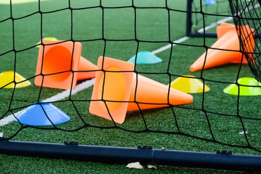 Soccer goal and cones on green artificial turf, sport background.