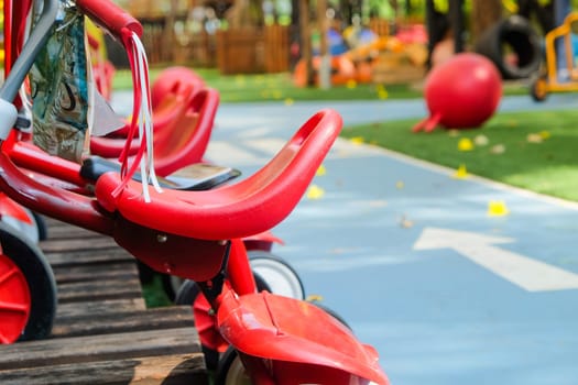 Red tricycle in the park, children's playground in the park