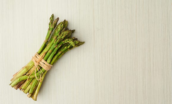 Asparagus, nutrition and vegan ingredients on table top for wellness, health and diet in studio. Vegetables, green and above isolated for eating, food and weight loss in house for prepare and cook