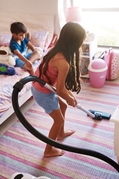 Girl, carpet and vacuum for cleaning in bedroom, house and at home for child development and growth. Lens flare, child and machine for responsible housekeeping, learning and chores for hygiene.
