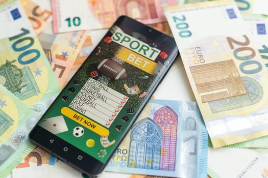 dollars and euros, smartphone with sports bet application. High quality photo
