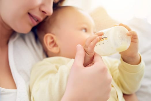 Mother, formula and baby drinking with bottle for nutrition, growth and childhood development at home. Care, infant and mom with feeding milk in house for love, motherhood and parenting of boy kid.