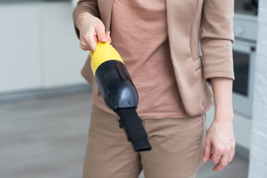 Female hand holding a portable vacuum cleaner cleaning the house, isolated on white background. File contains a path to isolation. High quality photo