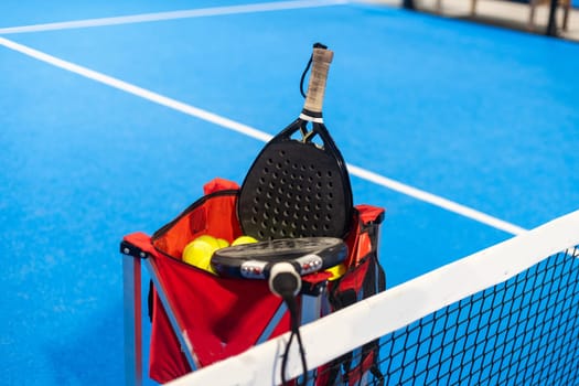 paddle tennis racket and balls on the blue paddle court. High quality photo