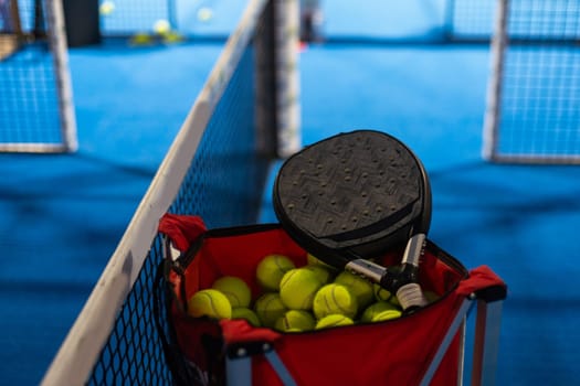 Paddle tennis rackets, balls and basket in court still life. High quality photo