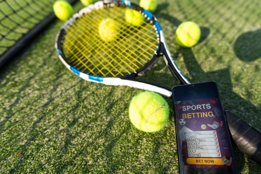 Ball with red racket leaning on tennis net at court during sunny day. unaltered, sport and tennis game concept. High quality photo