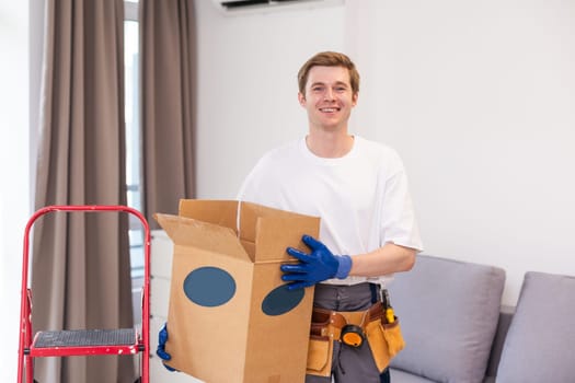 moving, people and real estate concept - happy smiling man holding boxes with stuff at new home.