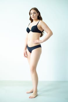 young woman with beautiful hair in black lingerie posing isolated on white background. Model test, snap, polaroid