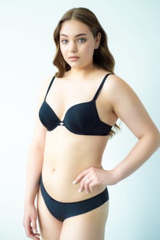 young woman with beautiful hair in black lingerie posing isolated on white background. Model test, snap, polaroid