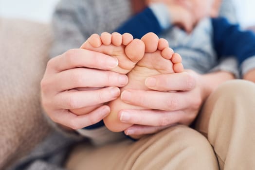 Mommy, baby and feet for love in home, security and support in bonding for wellness or trust. Mother, toddler and care for maternity or relax on couch, child development and comfort for single mom.