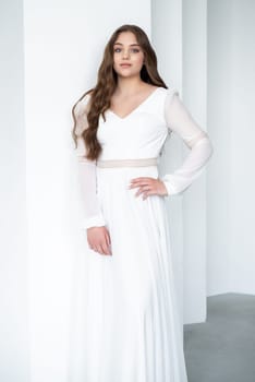 portrait of beautiful young woman in white wedding dress posing in studio