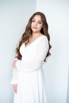 portrait of beautiful young woman in white wedding dress posing in studio