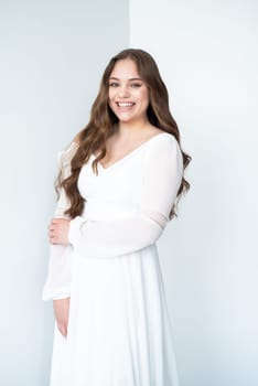 portrait of beautiful young woman in white wedding dress posing in studio