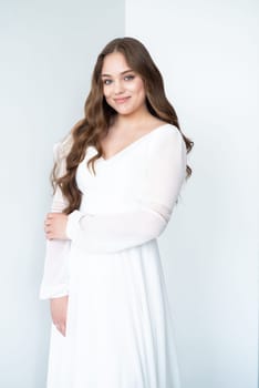 portrait of beautiful young woman in white wedding dress posing in studio