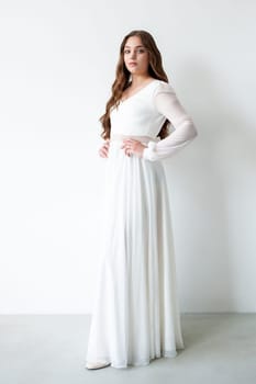 portrait of beautiful young woman in white wedding dress posing in studio