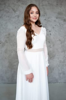 portrait of beautiful young woman in white wedding dress posing in studio