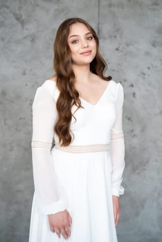 portrait of beautiful young woman in white wedding dress posing in studio