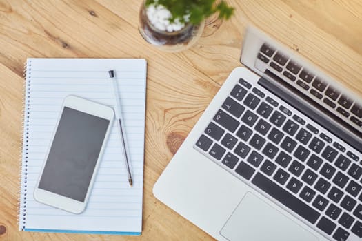 High angle, table or laptop or phone in closeup with paper, workspace with technology for background. Computer, smartphone or above on desk with pen in zoom, internet or app for marketing business.