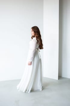 portrait of beautiful young woman in white wedding dress posing in studio