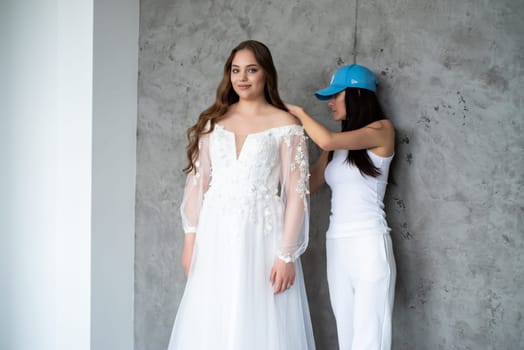 portrait of beautiful young woman in white wedding dress posing in studio