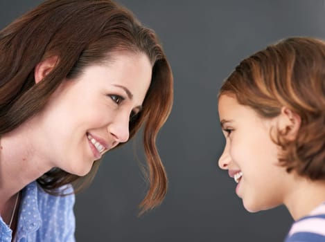 Mommy, girl and profile in studio for family, smile and security in love on gray background. Daughter, mother and happy together for trust or support, care and comfort in connection for bonding.