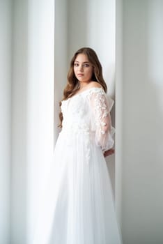 portrait of beautiful young woman in white wedding dress posing in studio