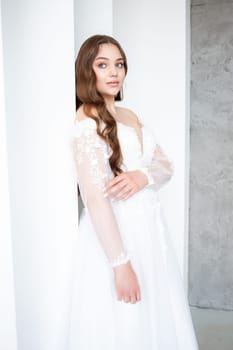 portrait of beautiful young woman in white wedding dress posing in studio