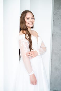 portrait of beautiful young woman in white wedding dress posing in studio