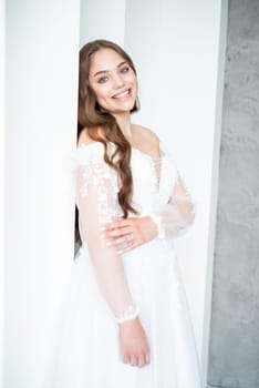 portrait of beautiful young woman in white wedding dress posing in studio