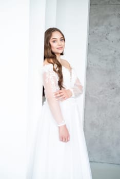 portrait of beautiful young woman in white wedding dress posing in studio