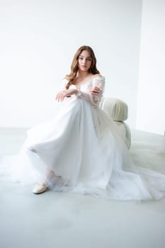 portrait of beautiful young woman in white wedding dress posing in studio