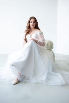 portrait of beautiful young woman in white wedding dress posing in studio