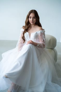 portrait of beautiful young woman in white wedding dress posing in studio