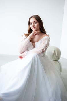 portrait of beautiful young woman in white wedding dress posing in studio