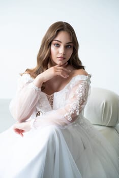 portrait of beautiful young woman in white wedding dress posing in studio