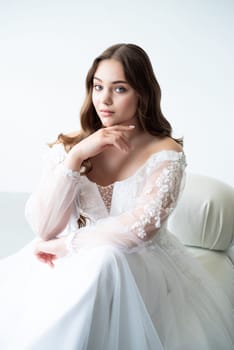 portrait of beautiful young woman in white wedding dress posing in studio